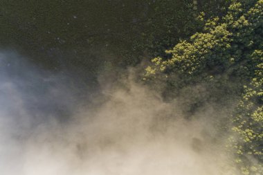 Yamacında sis olan bir dağın yukarıdan görünüşü..