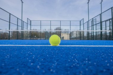 Mavi bir raket tenis kortunun taban çizgisinde bir topu görmek