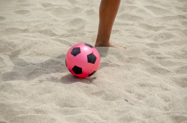 Plajda plastik bir top ve bir çocuk bacağı.