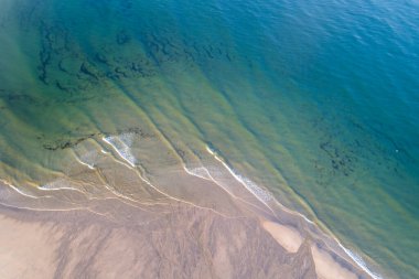 Güneşin doğuşundaki kumsalın insansız hava görüntüsü