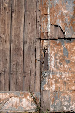 Eski kapı zamanla bozulmuş, ahşap ve paslı metal levhadan yapılmış. Antika