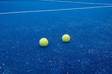 Mavi raket tenis kortunda iki top suni çim, raket sporu konsepti