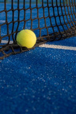 Seçici odaklanma, mavi raket tenis kortunun ağındaki raket tenis topu. Raket sporları