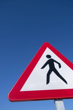 Dangerous pedestrian crossing traffic sign over a blue sky clipart