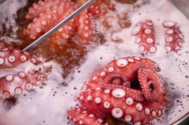 Galiçya 'nın geleneksel tarifi olan büyük bir tencerede tuzla birlikte suda kaynayan çiğ ahtapotun dokunaçlarını kapatın. Pulpo a feira