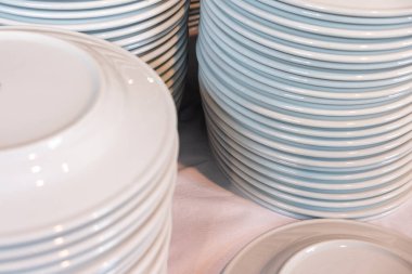 Yıkandıktan sonra yığınla beyaz seramik tabak.