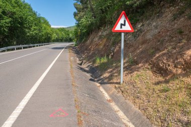 Asfaltta pembe jeodezik izler, yolda topoğrafya işaretleri.