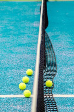 net of a blue paddle tennis court and five balls, racket sports concept clipart