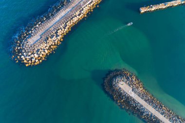Bir balıkçı teknesinin deniz kenarında korunan bir limana girdiği hava manzarası. Geçmişler ya da seyahat kavramları için ideal