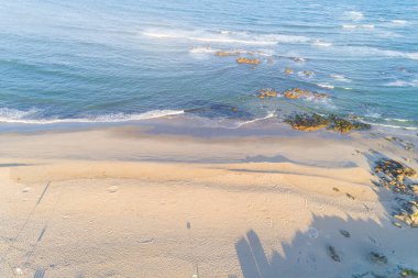 Yazın gün doğumunda boş bir plajın yukarıdan görünüşü, insansız hava aracı.