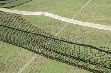 Terk edilmiş ve yıpranmış bir raket tenis kortunun detayları