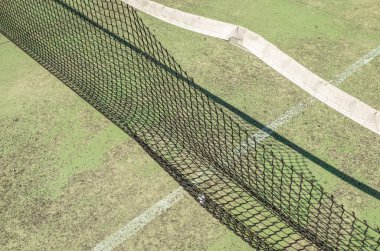 Terk edilmiş ve yıpranmış bir raket tenis kortunun ayrıntıları