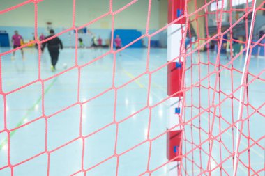 seçici odak, kapalı bir futbol kalesi ağı ve arka planda odaklanamayan oyuncular