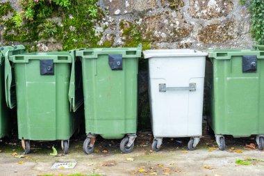 Sıraya dizilmiş dört plastik çöp konteyneri