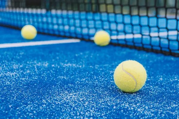 Seçici odak, raket tenis kortunun yanında üç raket tenis topu.