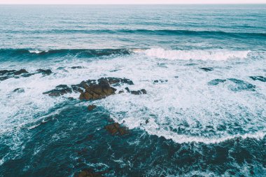 Bulutlu bir günde kayalık bir sahilin insansız hava görüntüsü