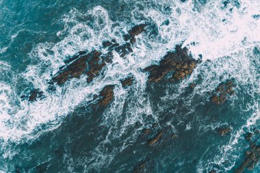 Kaya kıyısındaki dalgaların köpüğü, İHA 'lı havadan görüş.