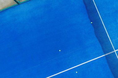 Mavi raket tenis kortunun üç toplu insansız hava aracı görüntüsü.