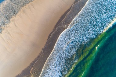 Güneş doğarken bir turkuaz su plajının kıyısı, İHA ile tepeden görünüşü, yaz deniz manzarası