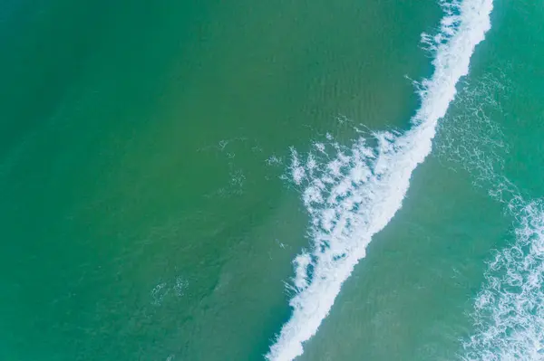 stock image zenithal view of the foam of a wave arriving to the coast, aerial photo with a drone. Summer background