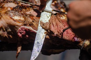 Seçici odaklanma, bıçaklı bir aşçı bir parça dana etinden parçalar kesiyor.