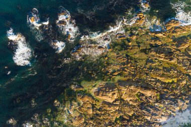 Yazın gün batımında kayalık kıyıların insansız hava aracı görüntüsü, zenital görüntü.