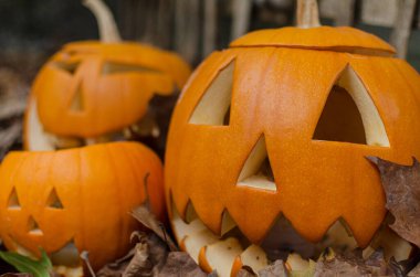 Üç cadılar bayramı balkabağı bir açık hava dekorasyonunda dökülen yapraklar üzerinde