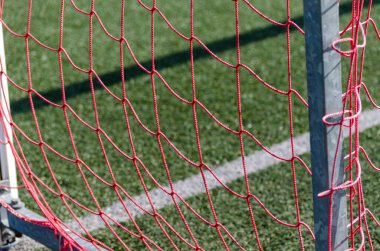 Yapay çim futbol sahasının kırmızı ağları.
