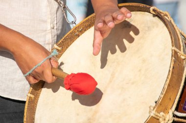 Geleneksel bir festivalde bas davul çalan bir müzisyenin elleri