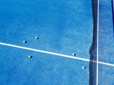 Mavi bir Padel tenis kortunda beş top, İHA 'nın en iyi görüntüsü.