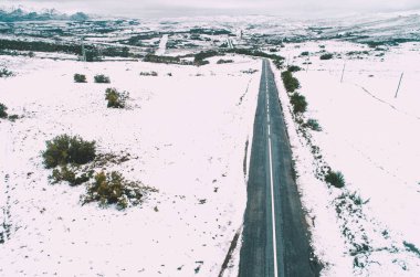 Karlı dağ manzarası ve kışın karla kaplı bir yol, İHA 'nın hava manzarası