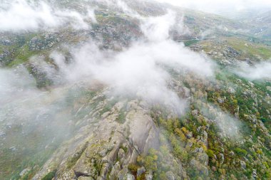 Zirvesinde sis olan kayalık bir dağın görüntüsü İHA 'dan görüldüğü gibi, havadan.