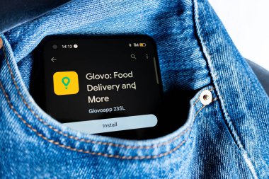 Madrid, İspanya 08-10-2024: Glovo Food Dağıtım uygulaması ile kot pantolon cebinde akıllı telefon