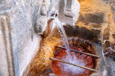 Ourense City 'deki As Burgaz' dan termal ve tıbbi suya uzanan bir kadın. Galiçya, İspanya