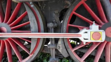 Terk edilmiş eski bir buhar makinesinin tekerlekleri. Paslı buhar treni tekerleği