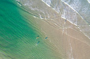 Sörfçüler plajda turkuaz suyla sörf yapıyor, drone 'la hava manzaralı. Yaz konsepti için arkaplan