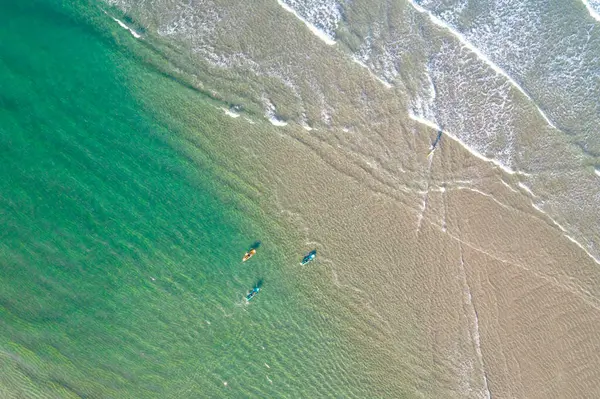 Sörfçüler plajda turkuaz suyla sörf yapıyor, drone 'la hava manzaralı. Yaz konsepti için arkaplan