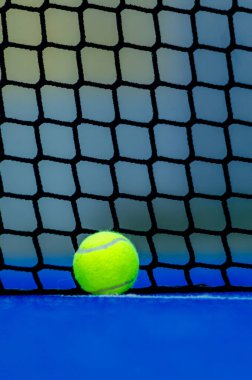Bir raket tenis kortunun dibindeki topun arka planı bulanık. Raket sporu arka planı.
