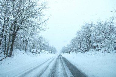 Kışın karla kaplı trafiği olmayan yol, dağ yolu arka planı kavramı.