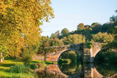 medieval bridge in Allariz over River Arnoia. Ourense, Galicia at sunset. Spain clipart