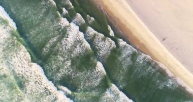 Dalgalar okyanus kenarını okşar, kıyı manzarasının okyanus kıyısındaki sükunetinde boş bir plaj. İHA üst görünümü. Yaz arkaplanı kavramı