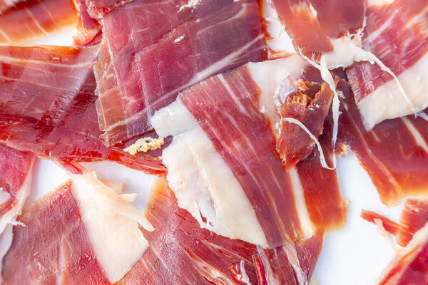 luxurious acorn-fed iberian ham in detail, slices of cured iberian acorn-fed cured ham, close-up zenithal view