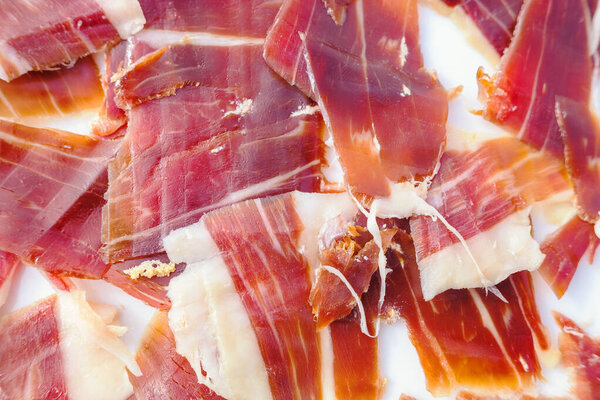 slices of cured acorn-fed iberian ham, close-up view. Exquisite iberian ham slices, detailed view