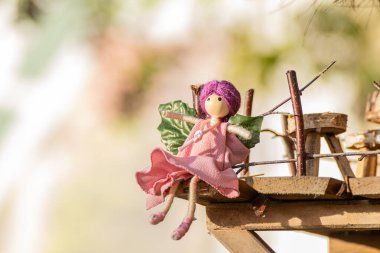 Yılbaşı süslemeleri için el yapımı oyuncak perisi, odak arkaplanı olmadan oturuyor.