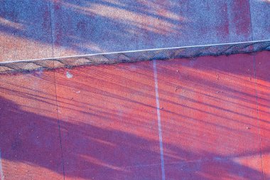 overhead aerial drone view of the net of a weathered red tennis court clipart