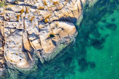 rocky coastline with turquoise sea water, aerial view with drone