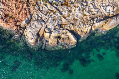 rocky coastline with turquoise sea water, aerial zenithal view with drone