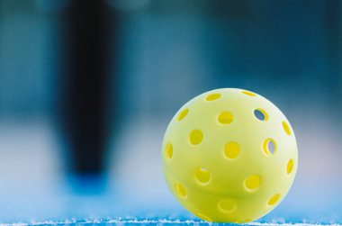 Pickleball sahasında yanlız top, raket sporları arka planı