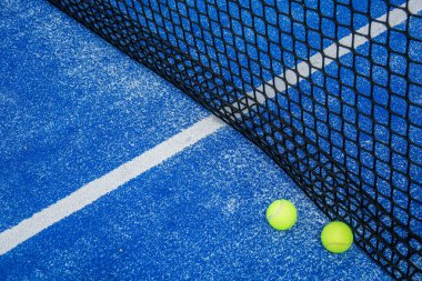 Mavi raket tenis kortu ve iki raket topu.