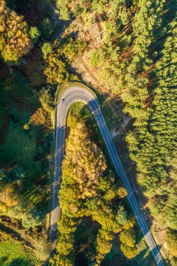 İlkbaharda bir dağ yolu eğrisinin hava aracı görüntüsünün hemen üstünde